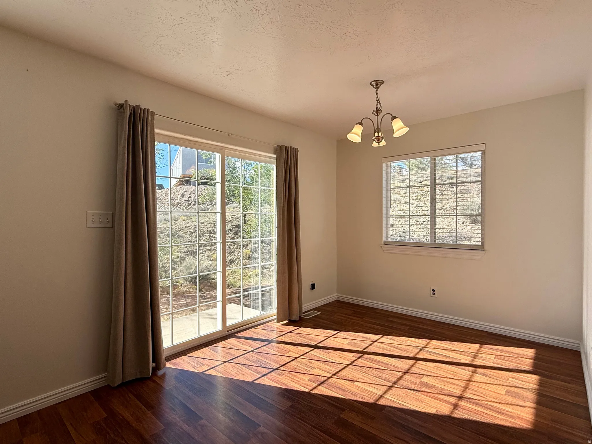 Wood-finish flooring, sliding glass door, white trim, recessed window, and a built-in ceiling light fixture