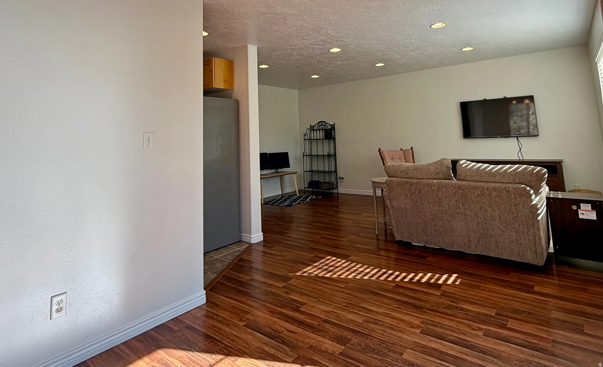 Recessed ceiling lighting, wood-finish flooring, and white walls