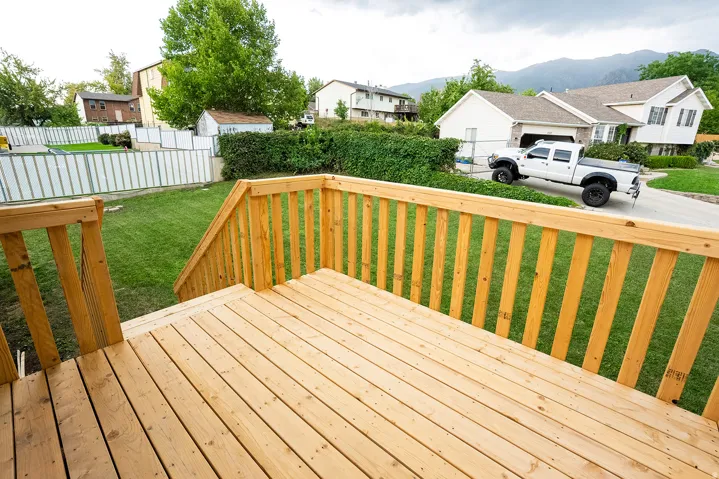 Expansive wood deck with natural finish, featuring a full railing and stairs