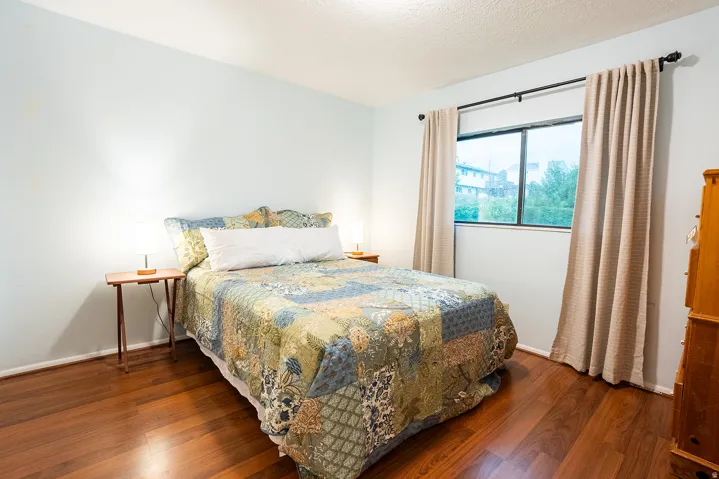 Wood-finish flooring, light blue wall paint, and a window with a black frame