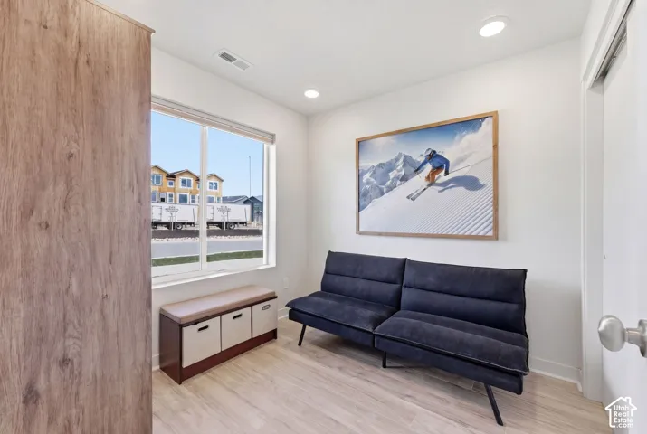 Room featuring wood-finish flooring, a large window with natural light, and recessed ceiling lighting