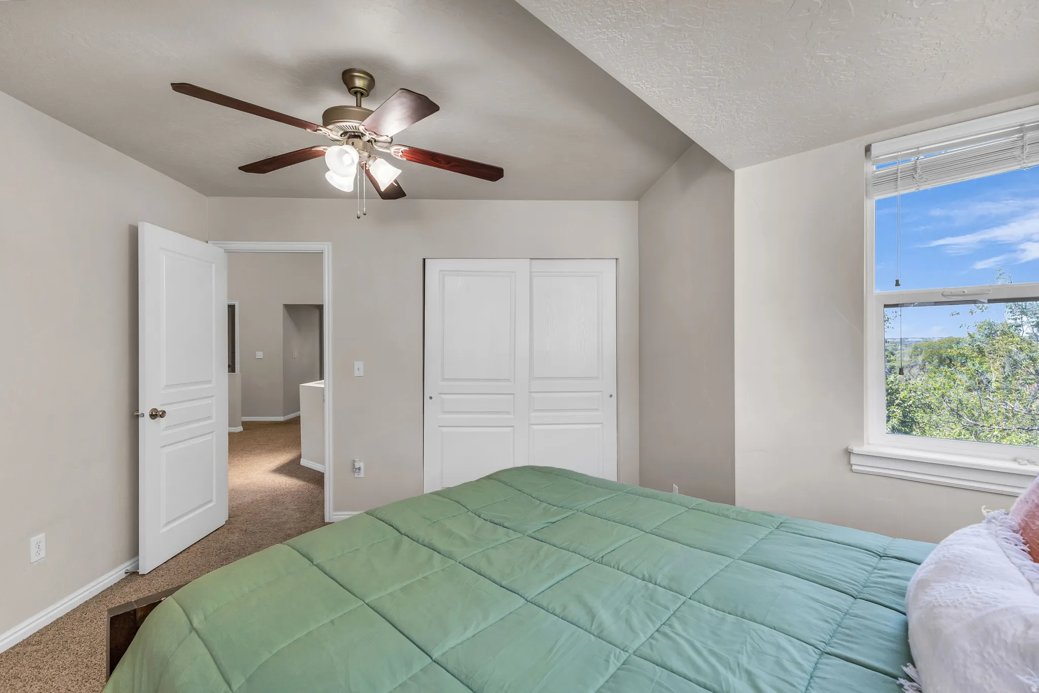 Recessed lighting, wood-finish ceiling fan, window with natural light, textured ceiling, and paneled closet doors