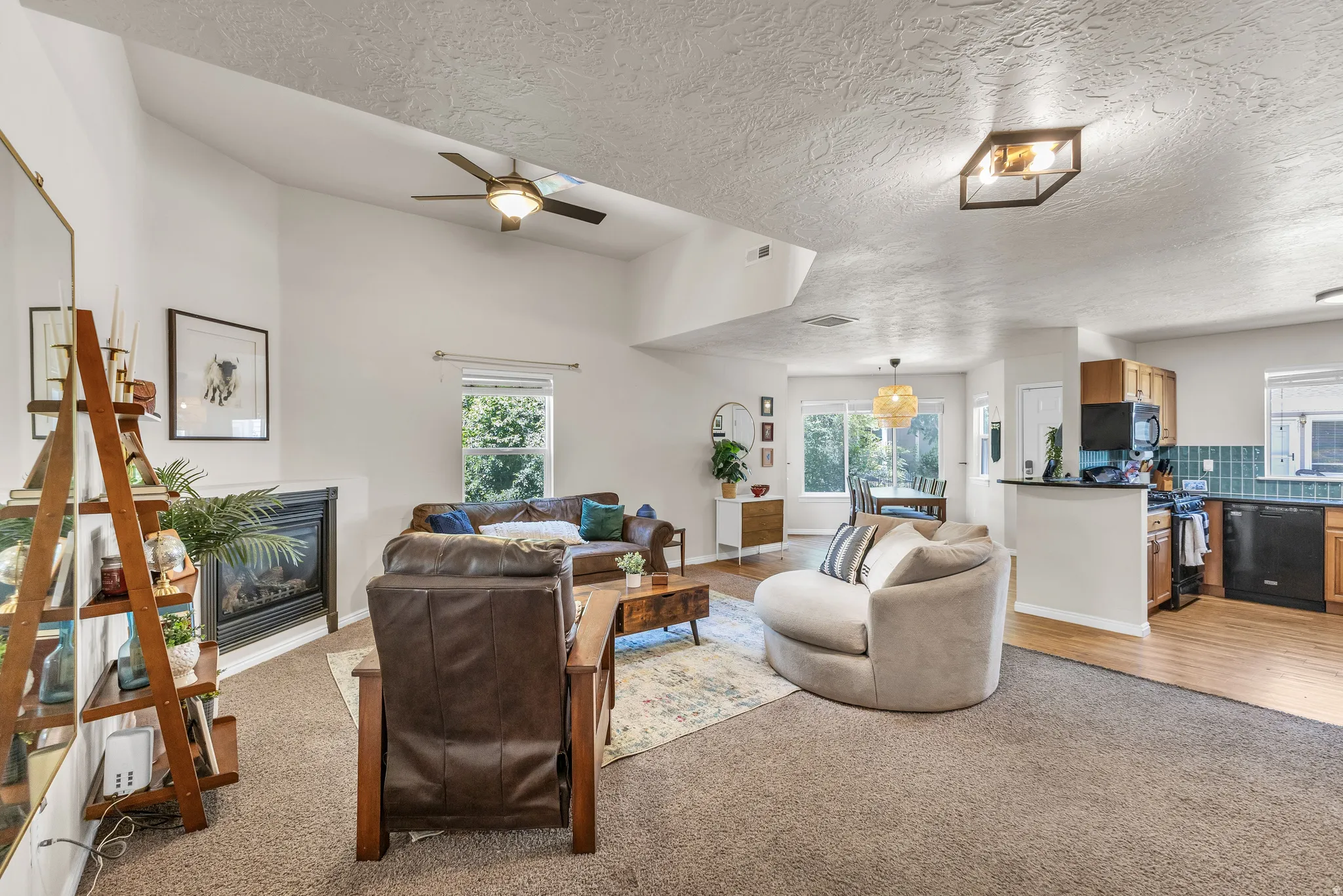Vaulted ceilings, a built-in fireplace, and a ceiling fan enhance the living area