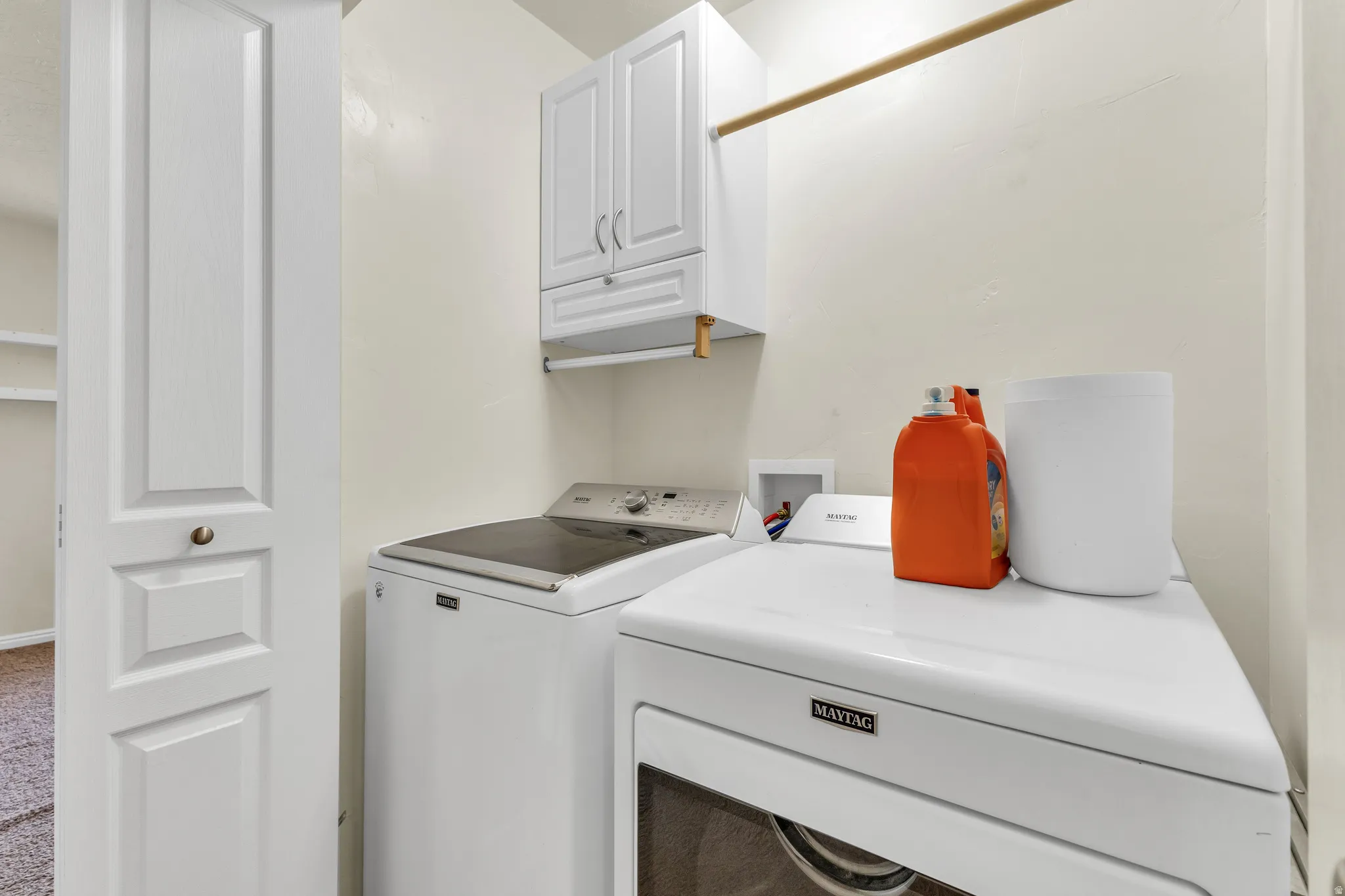 Built-in white cabinetry, wood finish hanging rod, and a bi-fold door