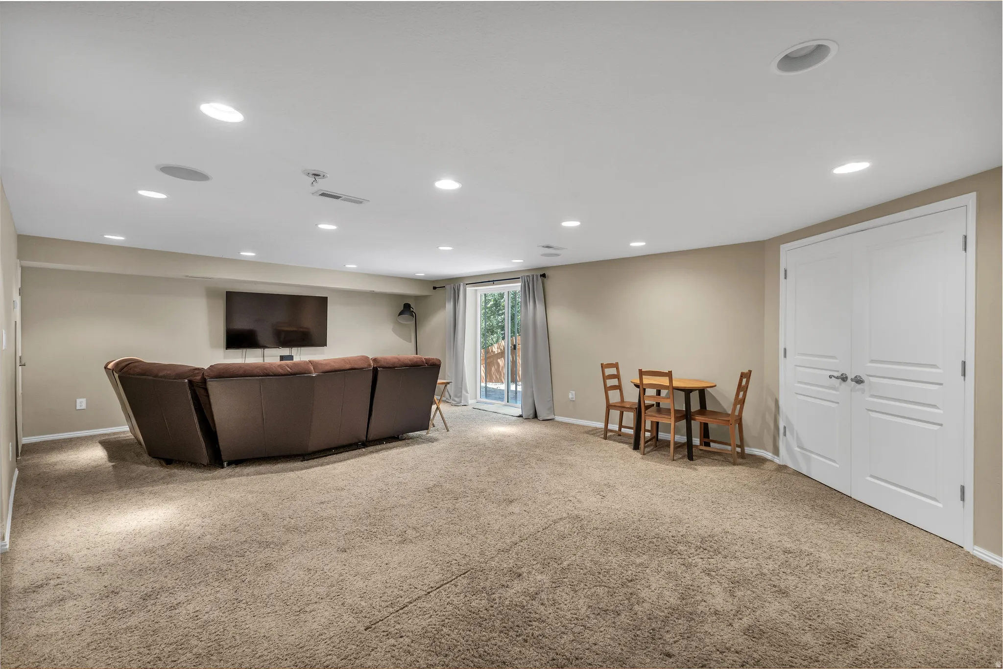 Recessed lighting, neutral-toned walls, and a glass sliding door