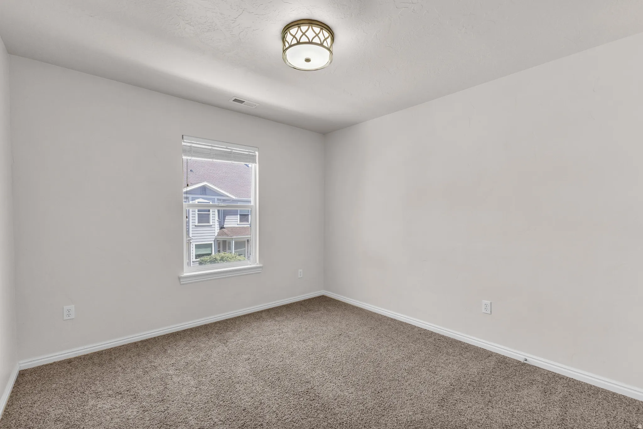 Neutral wall paint, carpet flooring, window with blinds, and a flush mount ceiling light fixture