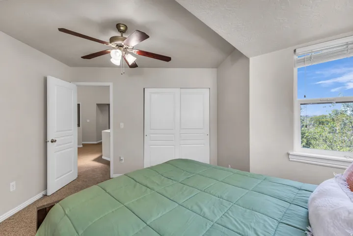 Recessed lighting, wood-finish ceiling fan, window with natural light, textured ceiling, and paneled closet doors