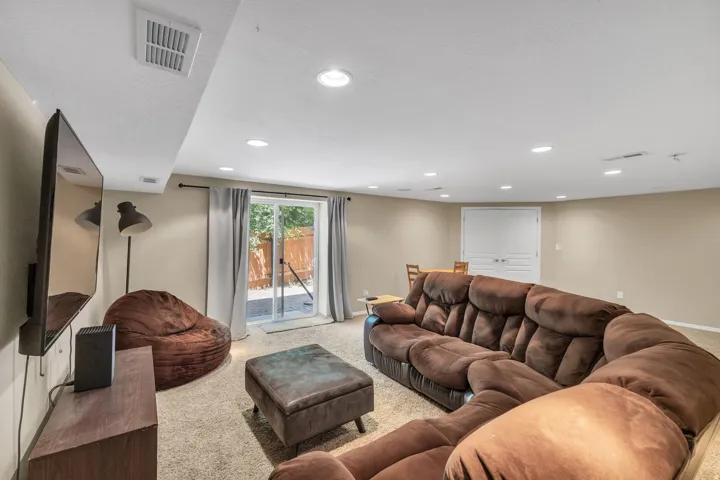 Recessed ceiling lighting, textured wall finishes, and a sliding glass door
