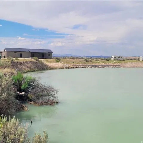 Expansive water feature with a natural bank, set against a backdrop of distant mountains