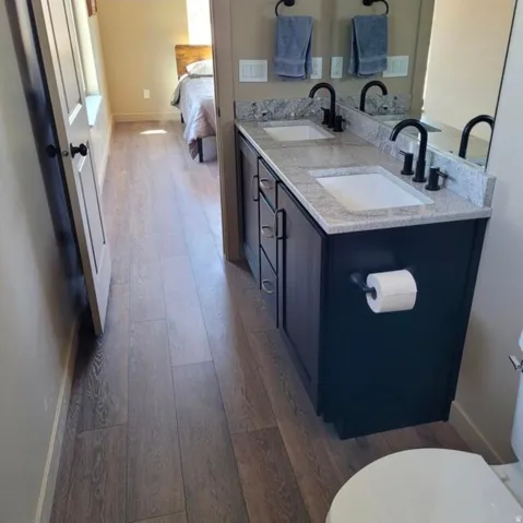 Double vanity with light-toned countertop, dual rectangular sinks, and matte black fixtures
