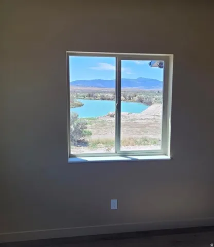 Sliding window offering expansive natural scenery, a prominent body of water, and distant mountains