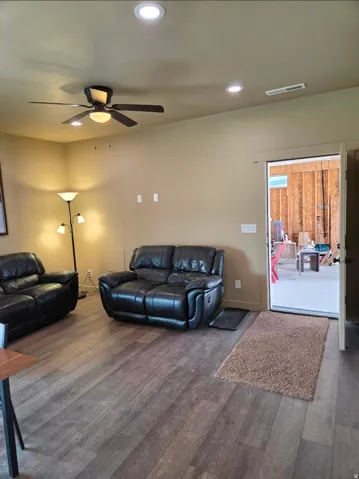 Wood-finish flooring, recessed lighting, and a ceiling fan with integrated lighting