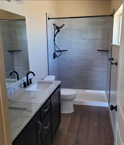 Dual vanity with granite-style countertop, undermount sinks, and matte black fixtures