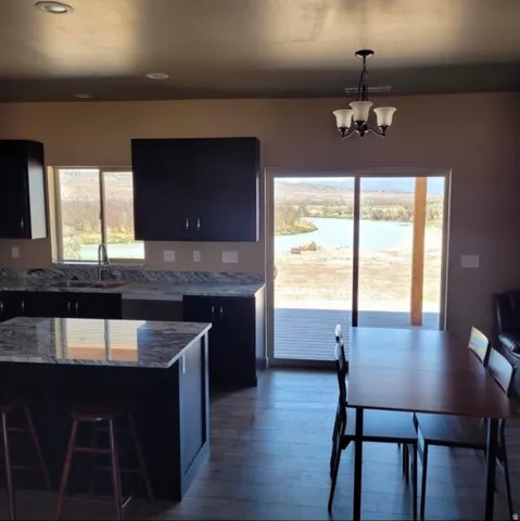 Kitchen with dark wood-finish flooring, dark cabinetry, and light-toned countertops