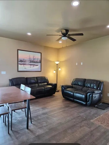 Recessed ceiling lighting, wood-finish flooring, and a ceiling fan with integrated light fixture