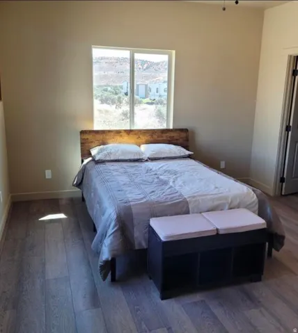 Expansive window, wood-finish flooring, neutral wall tones, recessed lighting, and a solid core door