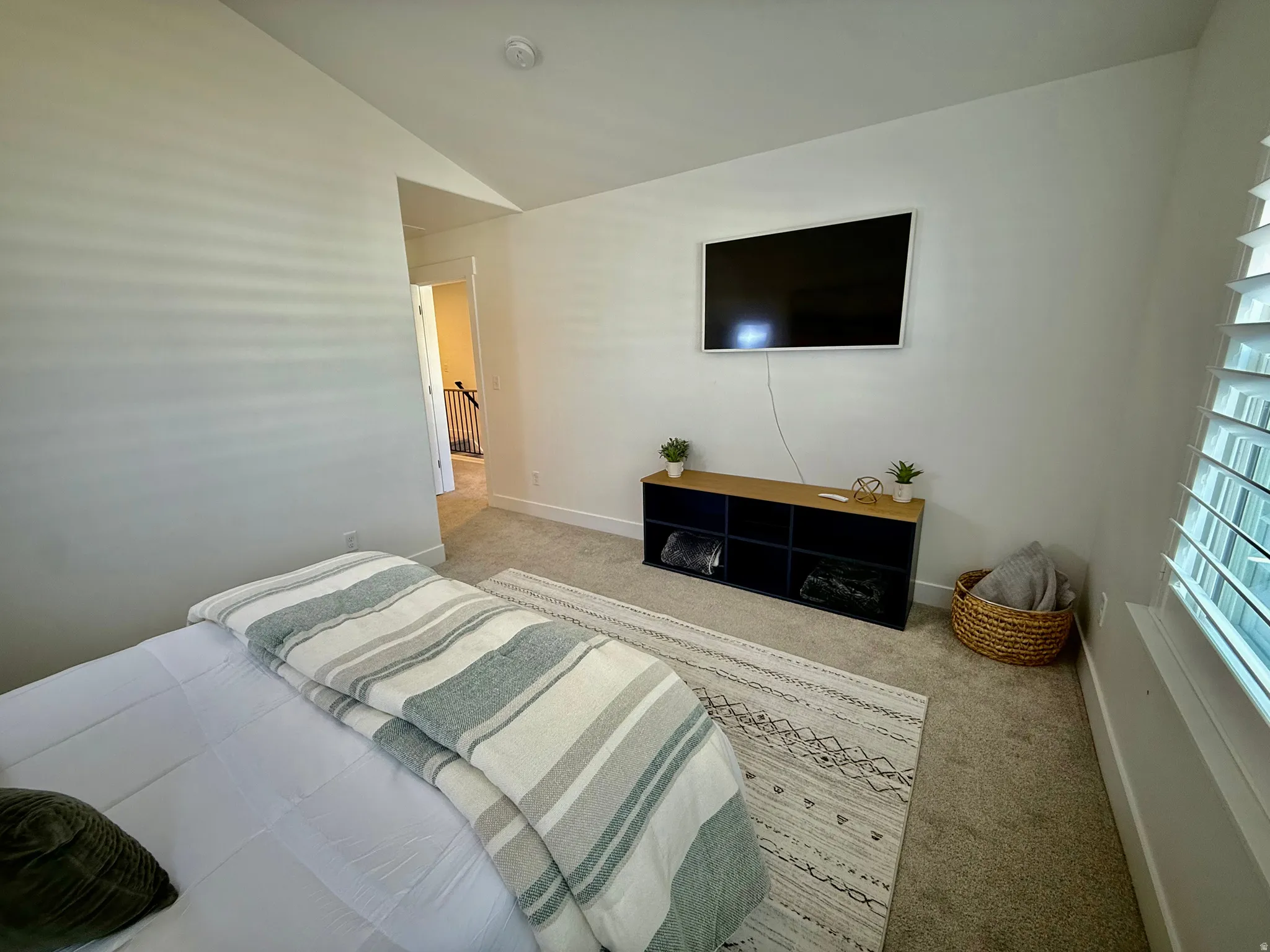 Recessed lighting, wall-mounted television, and carpeted flooring