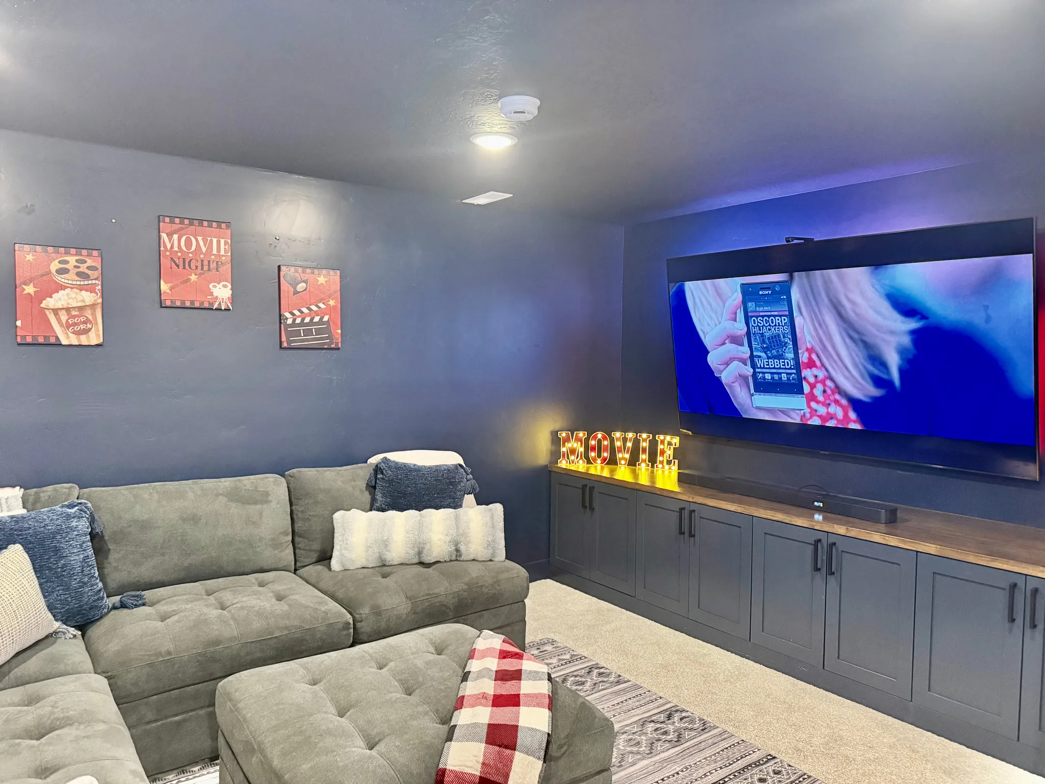 Built-in entertainment cabinetry with a wood-finish countertop, recessed ceiling lighting, and wall-mounted television