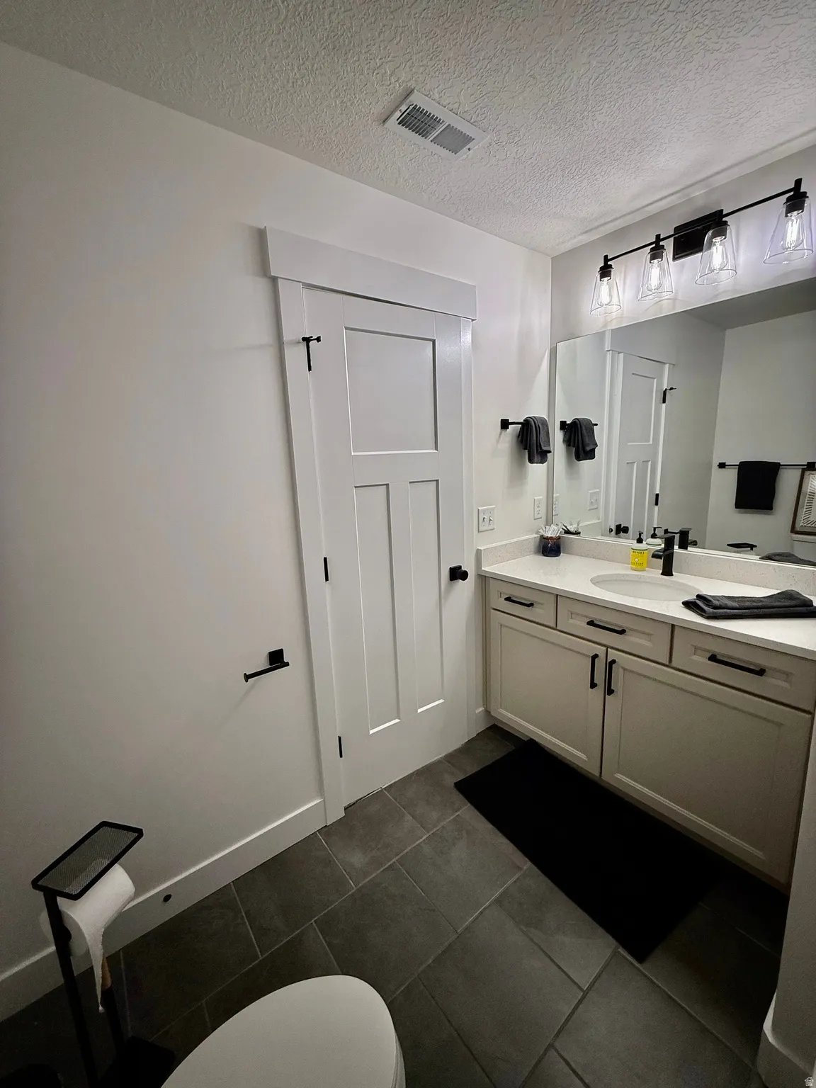 Dual-sink vanity with light cabinetry and solid-surface countertop