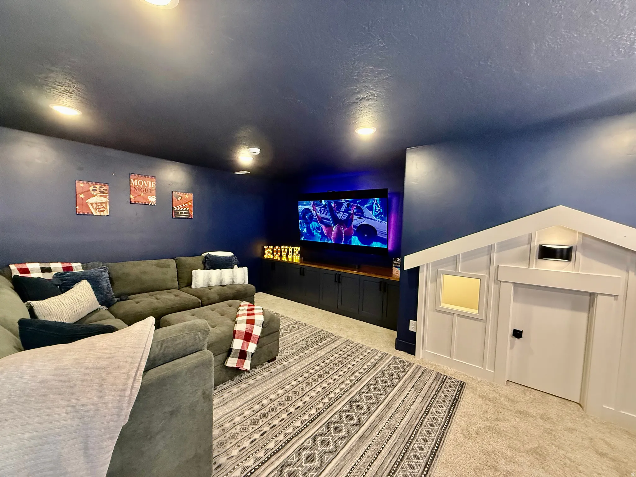 Built-in entertainment center, recessed lighting, accent wall, built-in playhouse structure, and carpeted flooring