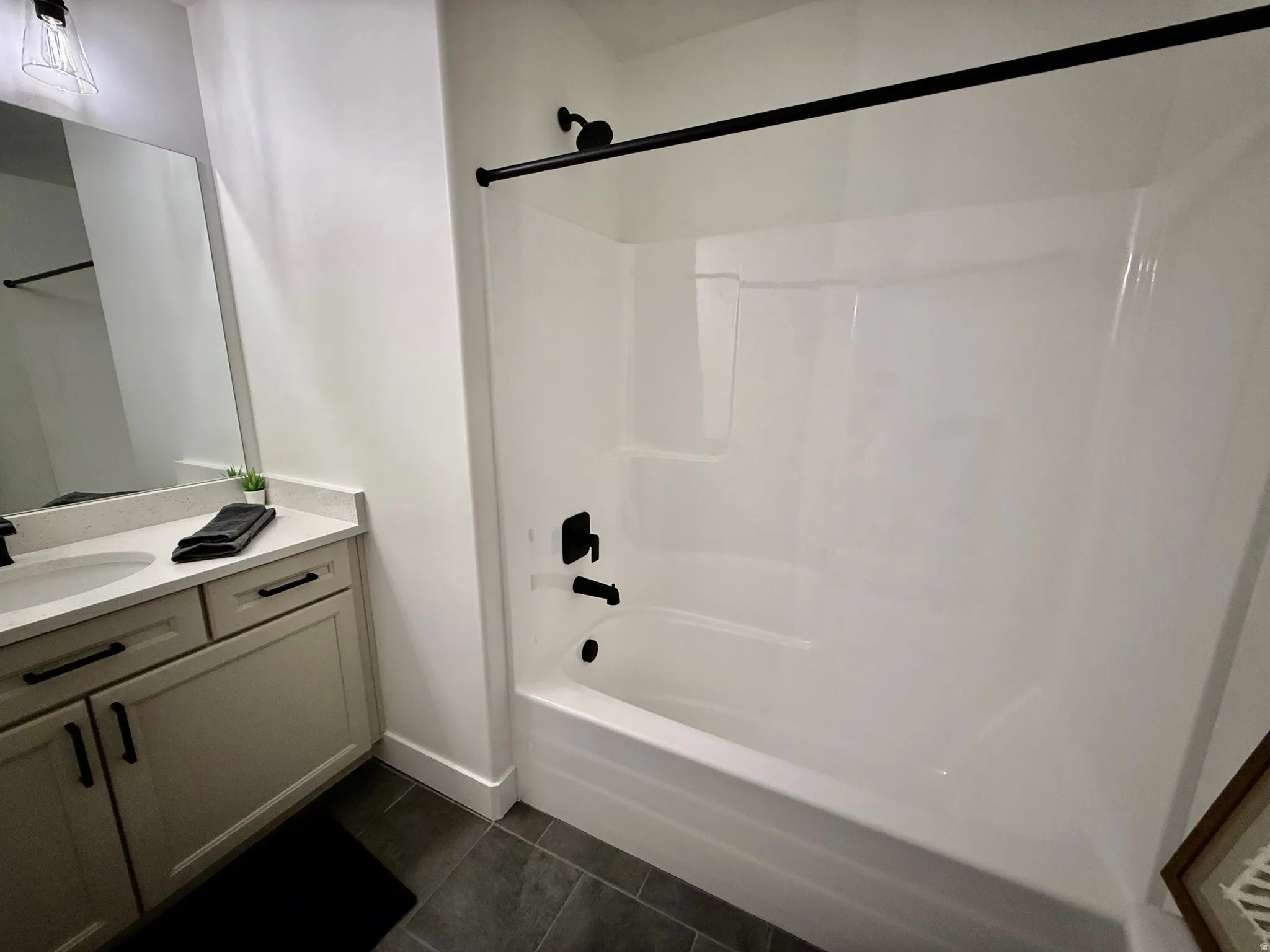 White tub and shower combination with matte black fixtures