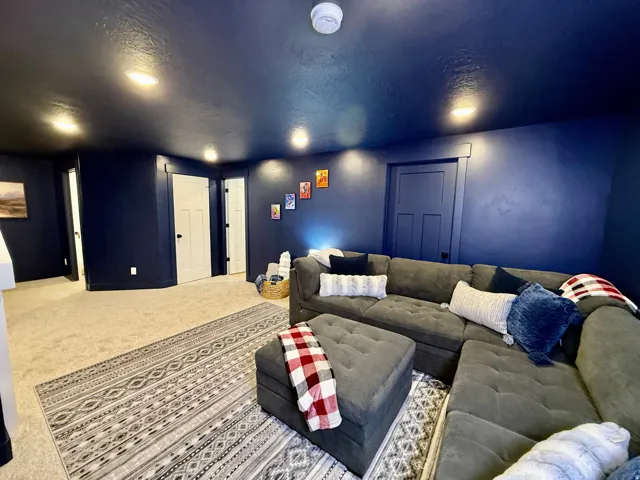 Recessed lighting illuminates deep blue walls and a carpeted floor