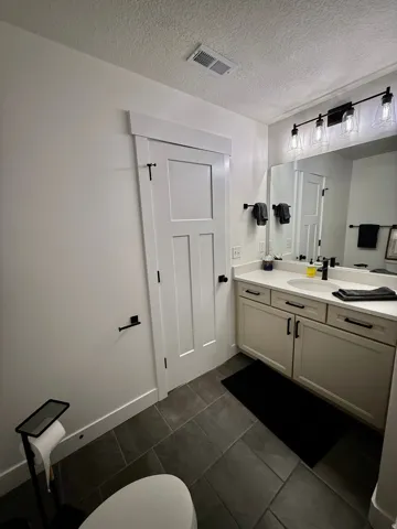 Dual-sink vanity with light cabinetry and solid-surface countertop
