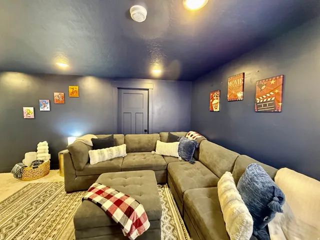 Recessed lighting illuminates the room with dark blue walls, complemented by a panel door and light-colored carpet