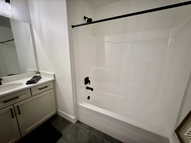 White tub and shower combination with matte black fixtures