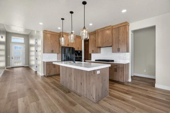 Gourmet kitchen with wood-finish cabinetry, white countertops, and subway tile backsplash
