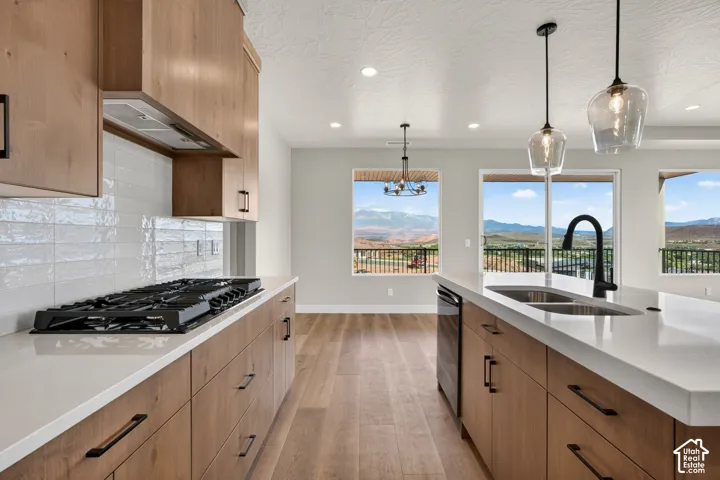 Kitchen featuring wood cabinetry, white countertops, a gas range, and a dual basin sink with a matte black faucet