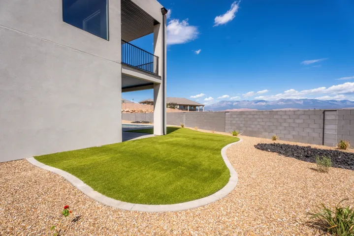 Contemporary exterior with a balcony, synthetic turf lawn, and gravel landscaping