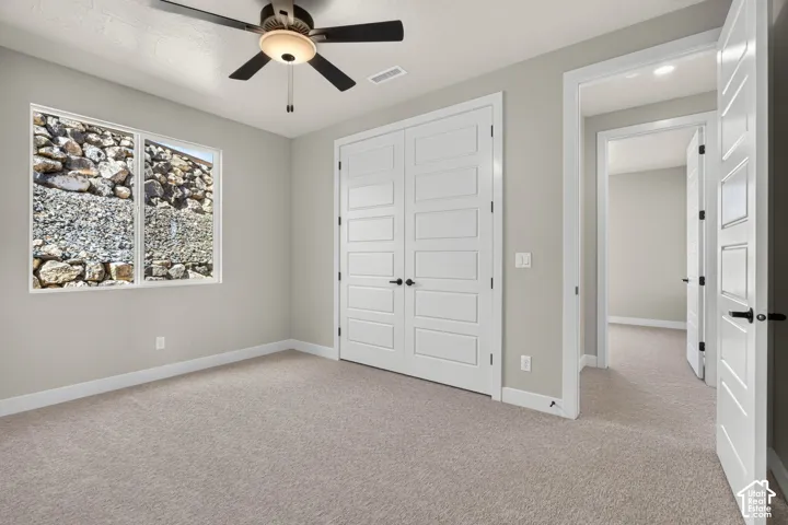 Neutral-toned carpeting, light gray walls, and white trim