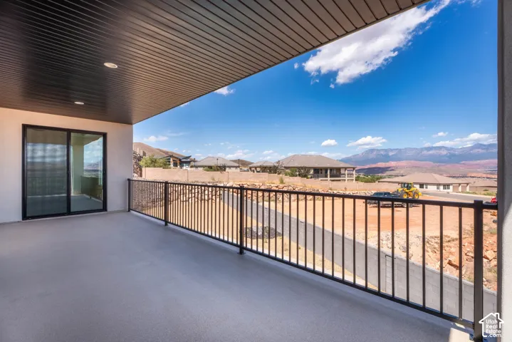 Covered patio with recessed lighting, sliding glass door, and black metal railing
