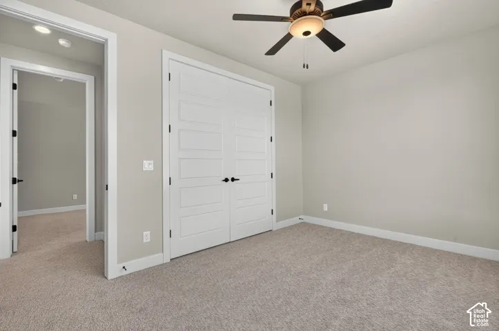 Recessed lighting, ceiling fan with integrated light, light-colored carpeting, white trim, and white doors with dark hardware