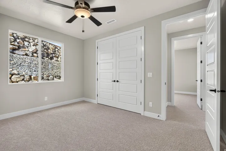 Neutral-toned carpeting, light gray walls, and white trim