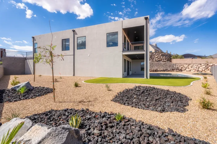 Contemporary exterior with a covered balcony, recessed lighting, and a ground-level patio