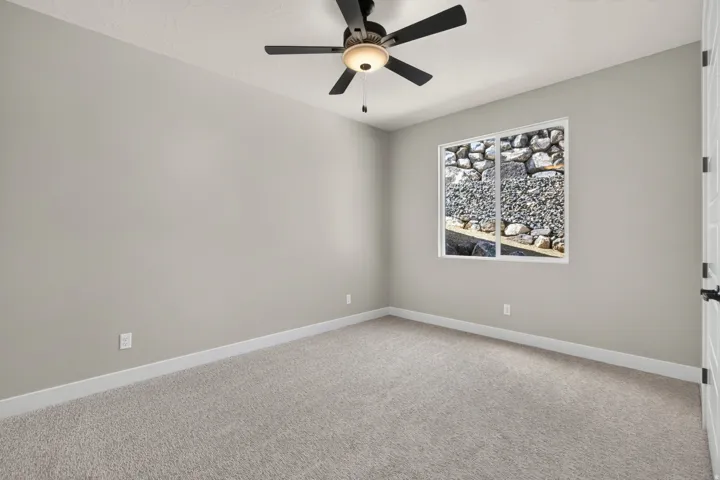 Recessed window, textured carpeting, ceiling fan with integrated lighting, and neutral wall finish