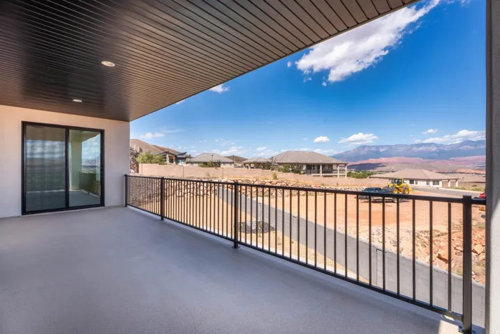 Covered patio with recessed lighting, sliding glass door, and black metal railing