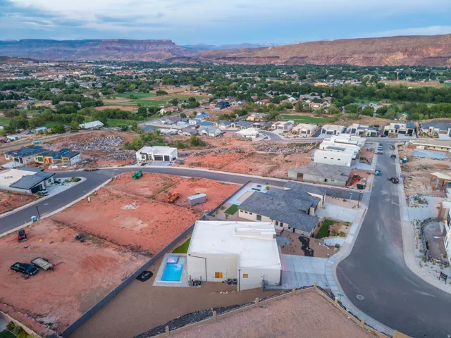Aerial perspective showcasing the surrounding residential area and distant mountainous terrain