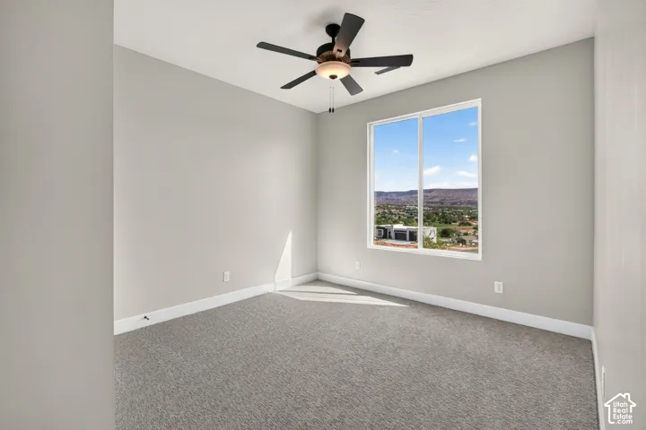 Recessed lighting, ceiling fan, carpeting, and a window with distant mountain scenery