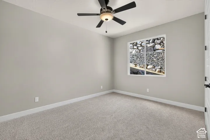 Recessed window, textured carpeting, ceiling fan with integrated lighting, and neutral wall finish