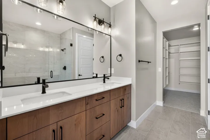 Dual vanity with wood-finish cabinetry, quartz countertops, and matte black fixtures