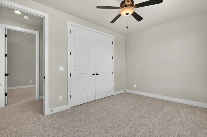 Recessed lighting, ceiling fan with integrated light, light-colored carpeting, white trim, and white doors with dark hardware