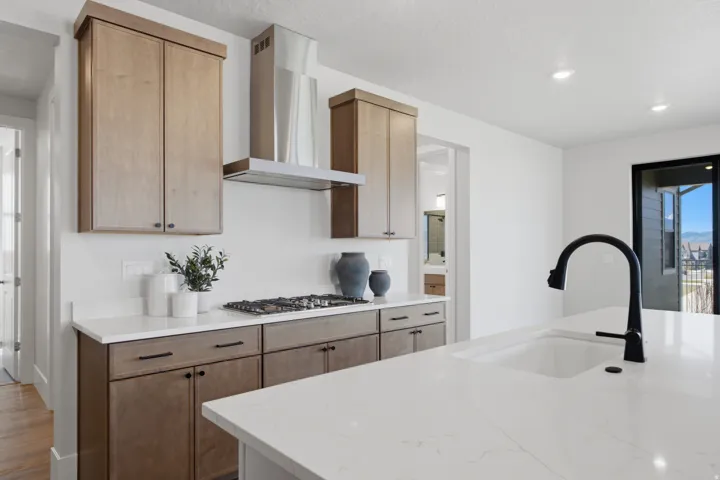 White countertop island with an integrated sink and a matte black faucet