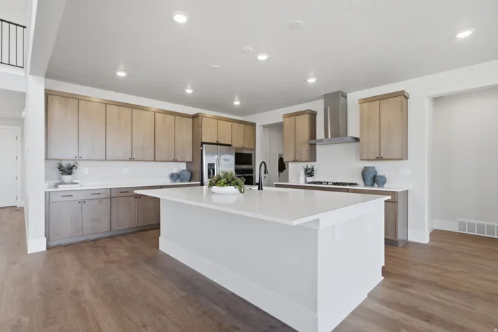Kitchen featuring wood-finish cabinetry, stainless steel appliances, a center island with a white countertop and recessed lighting