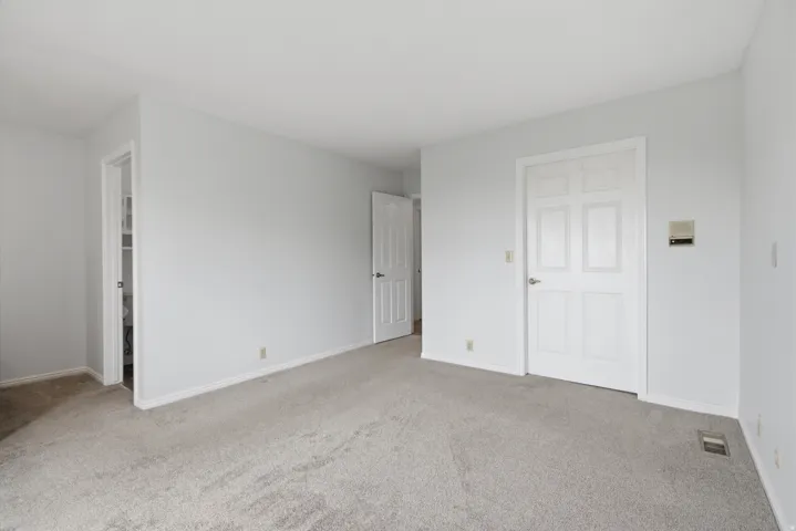 Neutral wall color, light-toned carpet flooring, and white trim