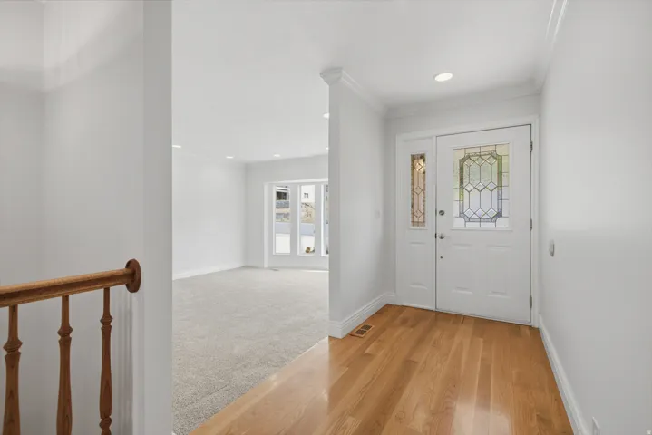 Entryway featuring wood-finish flooring, a decorative glass front door, and a matching sidelight