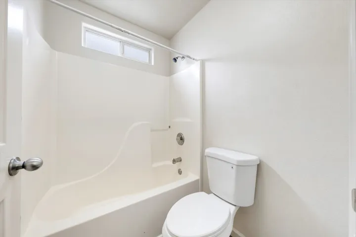 Bathtub and shower combination unit featuring an integrated soap dish and a frosted transom window