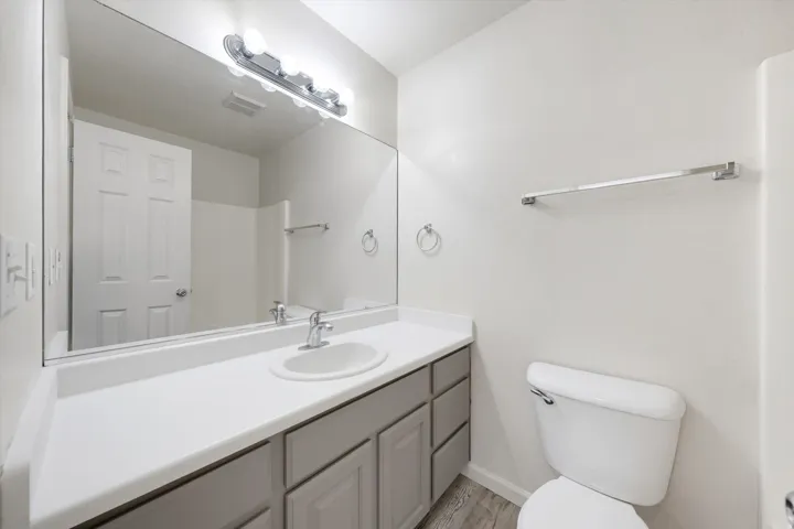 Vanity with an integrated sink, polished chrome faucet, and gray cabinetry with polished chrome hardware